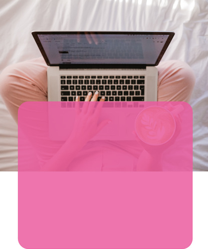 Lady holding coffee and working on laptop from bed