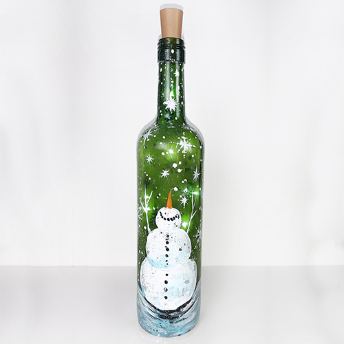 A Snowman in Snowstorm Wine Bottle with Fairy Lights paint nite project by Yaymaker